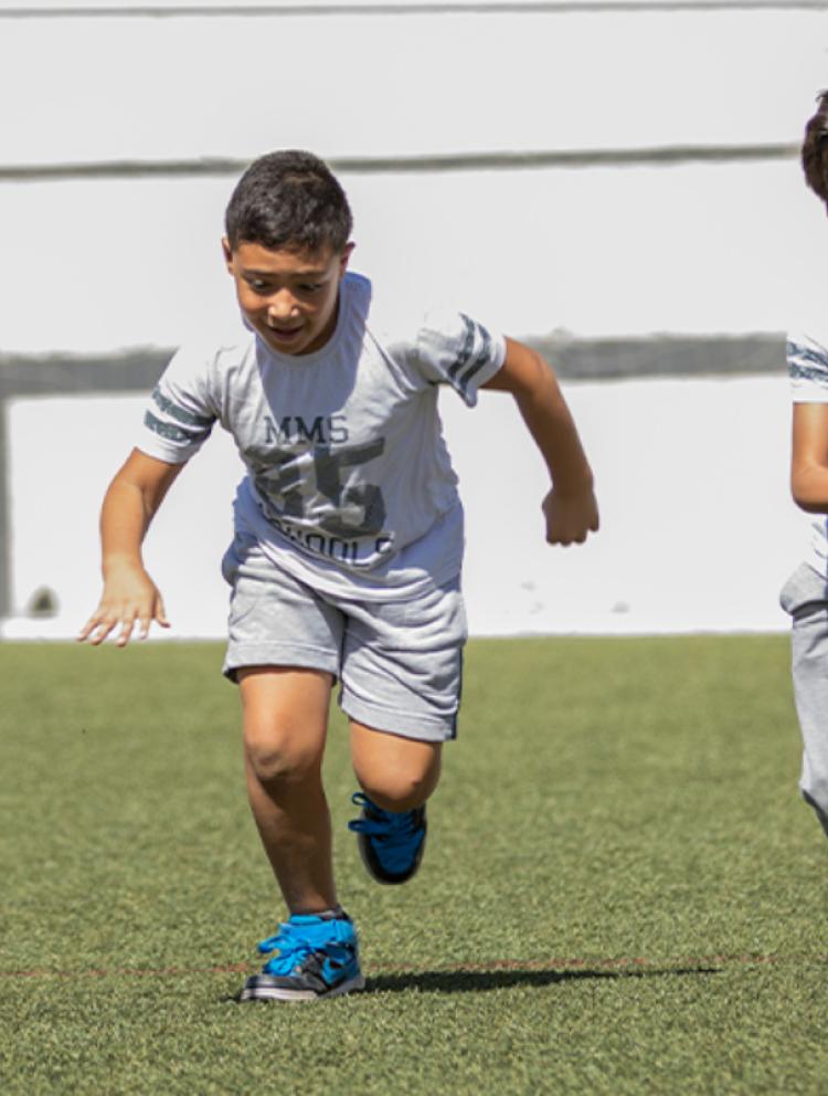 a_group_of_four_mms_boys_running_joyfully_on_a_soccer_field