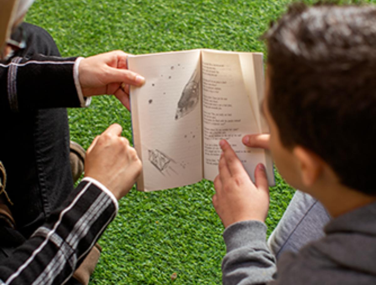 student and a teacher reading a book